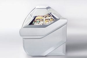A modern, silver gelato display case with a glass front, showcasing several flavors of gelato topped with colorful decorations. The design is sleek and futuristic against a plain background.