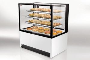 A refrigerated display case with glass sides showcasing shelves filled with assorted pastries, sandwiches, and baked goods, arranged neatly inside a modern white and black case.