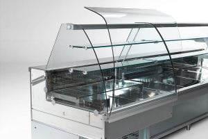 A modern, empty refrigerated display case with clear glass panels and metal shelves, designed for showcasing food items in a deli, bakery, or supermarket setting.