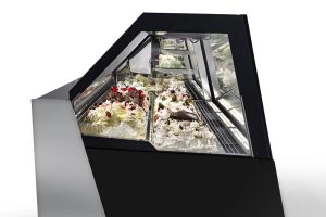 A modern gelato display case with glass panels showcases trays of assorted gelato flavors, including varieties topped with chocolate, whipped cream, and cherries. The background is white and minimalistic.