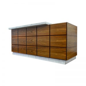 Modern rectangular counter with a wood paneled front and sides, featuring horizontal black lines and a white marble top and base, set against a white background.