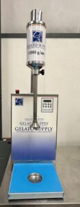 A stainless steel gelato supply machine with a digital display, labeled “12000 g/min, stands on a blue and silver base with Gelato Supply branding, against a plain background.